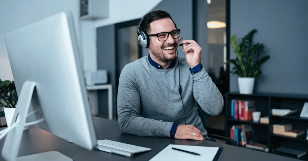 Profissional de suporte técnico na loja autônoma atendendo clientes com headset em ambiente corporativo moderno